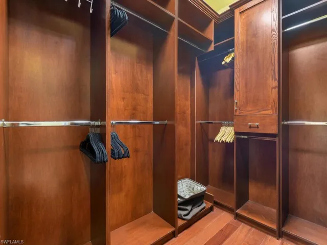 Walk in closet with cherry wood build ins.