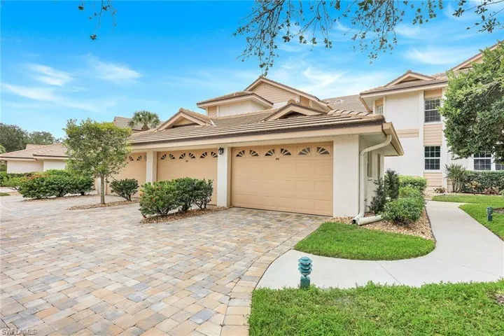 View of front of property with stucco siding, decorative driveway, and a garage