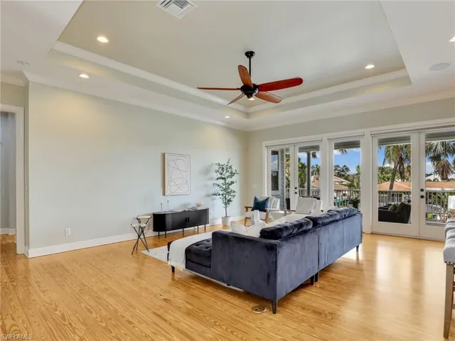 Living room featuring french doors, a raised ceiling, and light hardwood / wood-style floors