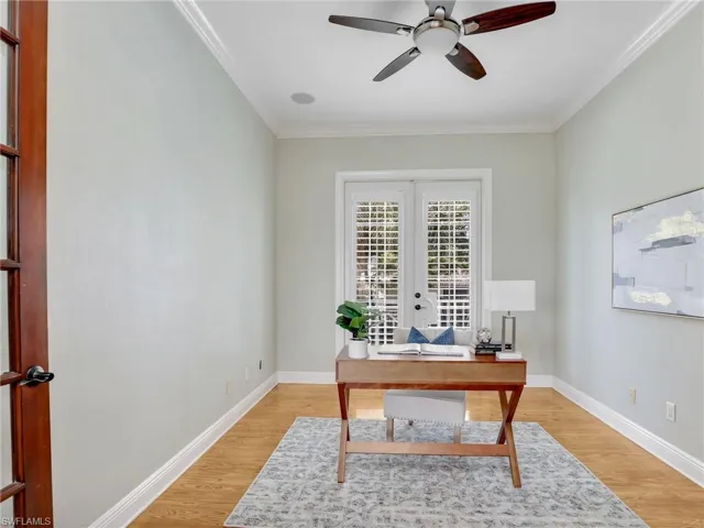 Office area featuring crown molding, ceiling fan, light hardwood / wood-style floors, and french doors