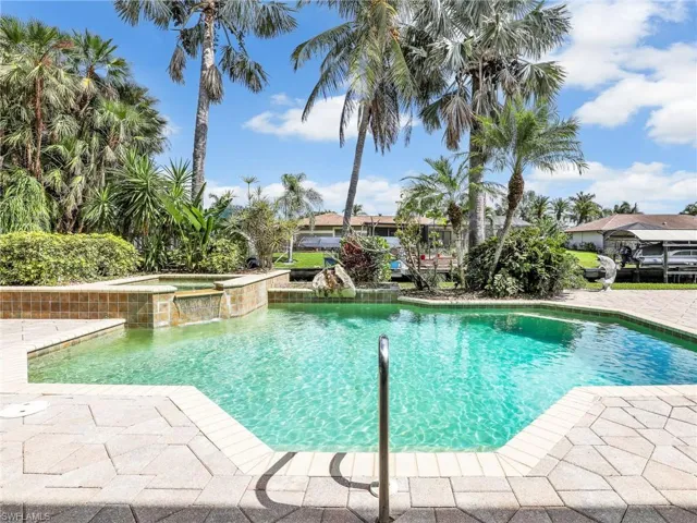 View of pool with an in ground hot tub, pool water feature, and a patio area