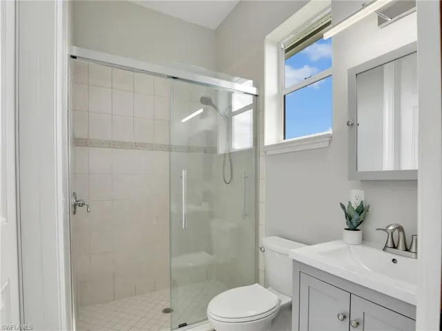Bathroom with vanity, toilet, and a shower with door