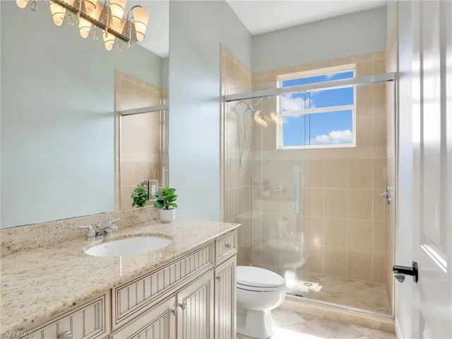 Bathroom with an enclosed shower, vanity, and toilet