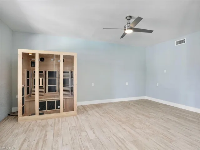 Unfurnished living room featuring ceiling fan and light hardwood / wood-style floors