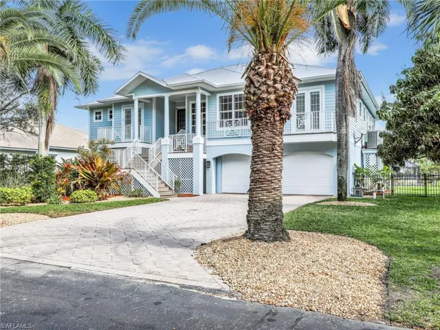 View of front of house featuring a garage, a front yard, and a porch