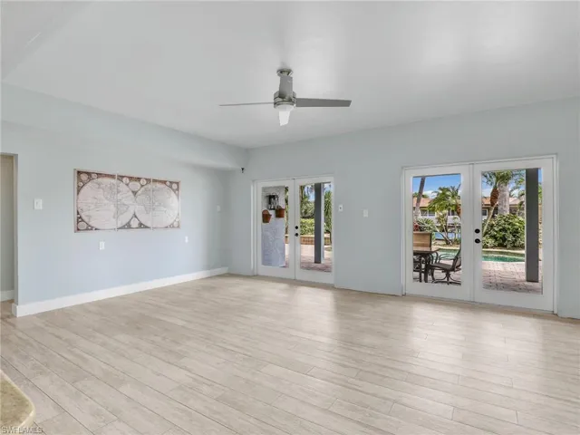 Unfurnished living room with light hardwood / wood-style flooring, plenty of natural light, and french doors