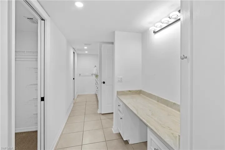 Bathroom featuring vanity, recessed lighting, light tile patterned flooring, and a walk in closet