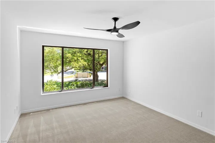Spare room featuring light carpet and ceiling fan