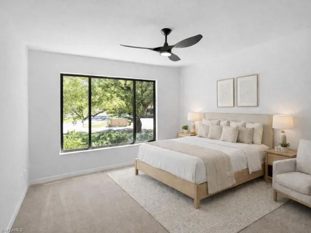 Bedroom with light colored carpet, a ceiling fan, and a textured ceiling