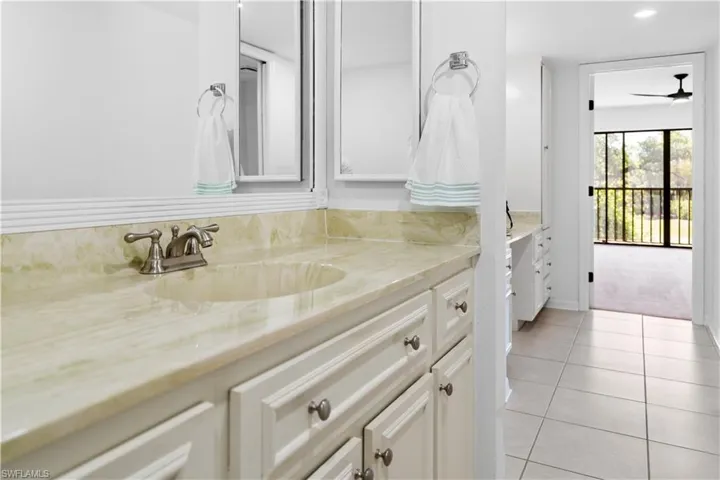 Bathroom with vanity, light tile patterned floors, a ceiling fan, and recessed lighting