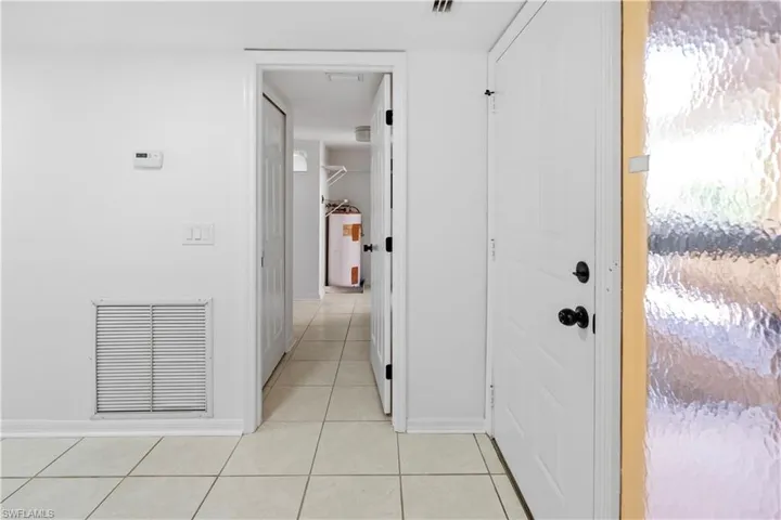 Hallway with light tile patterned floors and baseboards