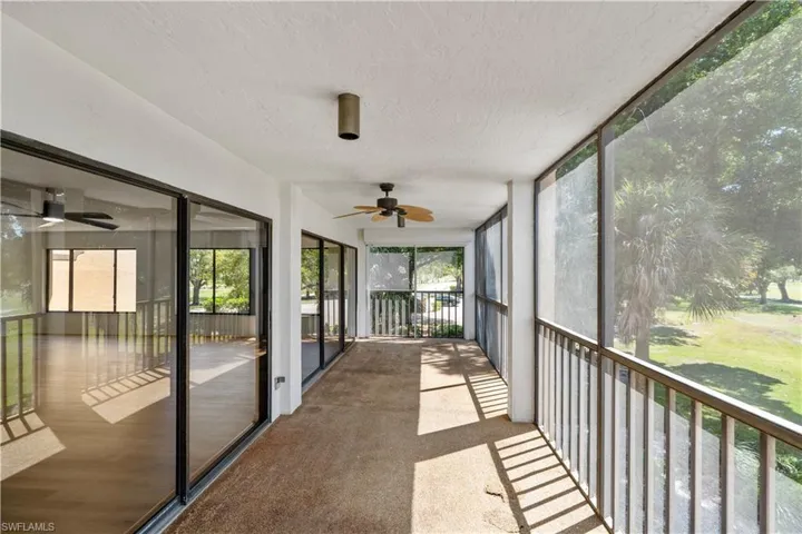 Unfurnished sunroom with ceiling fan, healthy amount of natural light, and a balcony