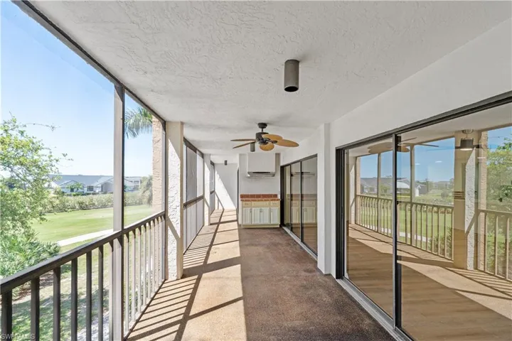 Unfurnished sunroom with plenty of natural light, ceiling fan, and a residential view