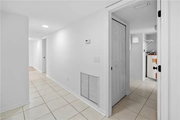 Corridor with light tile patterned floors and recessed lighting