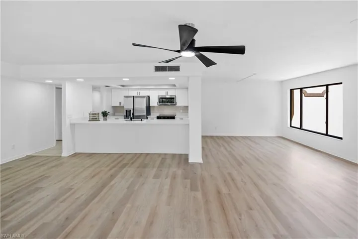 Unfurnished living room with light wood-style flooring, ceiling fan, and recessed lighting