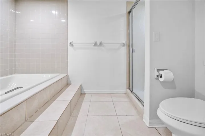 Bathroom featuring a stall shower, light tile patterned floors, and a bath