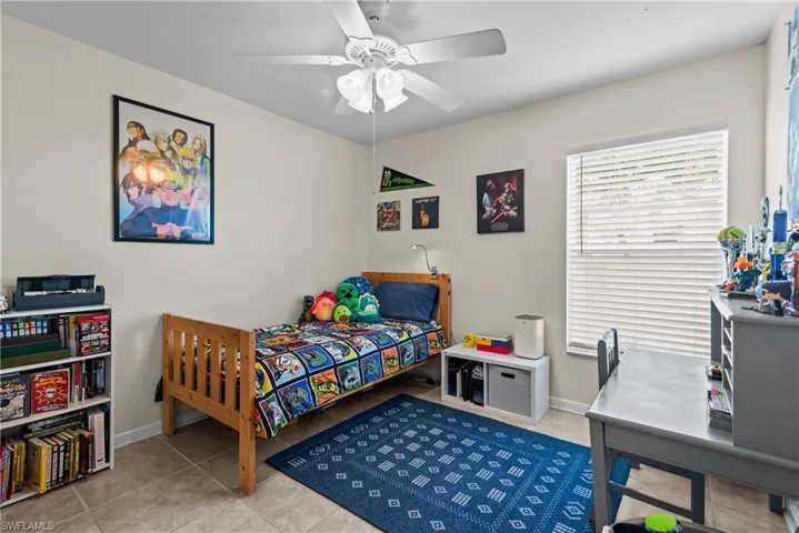Bedroom with light tile patterned flooring and ceiling fan