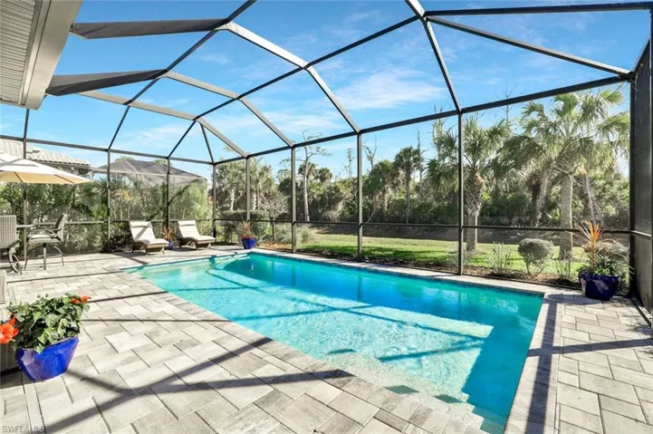 Outdoor pool with a sunroom, a lanai, and a patio area