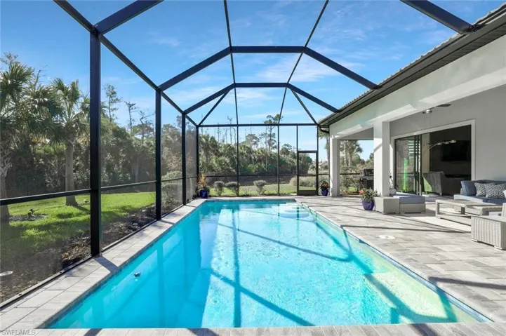 Outdoor pool featuring a sunroom, a patio area, a lanai, and an outdoor living space