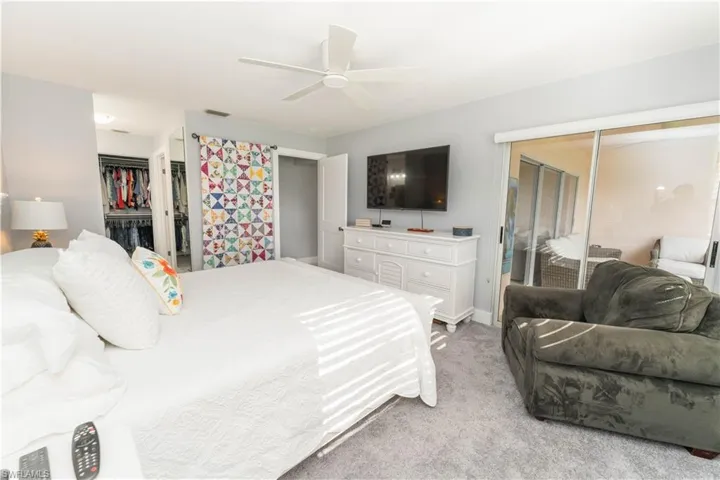 Bedroom with light colored carpet, ceiling fan, and access to exterior