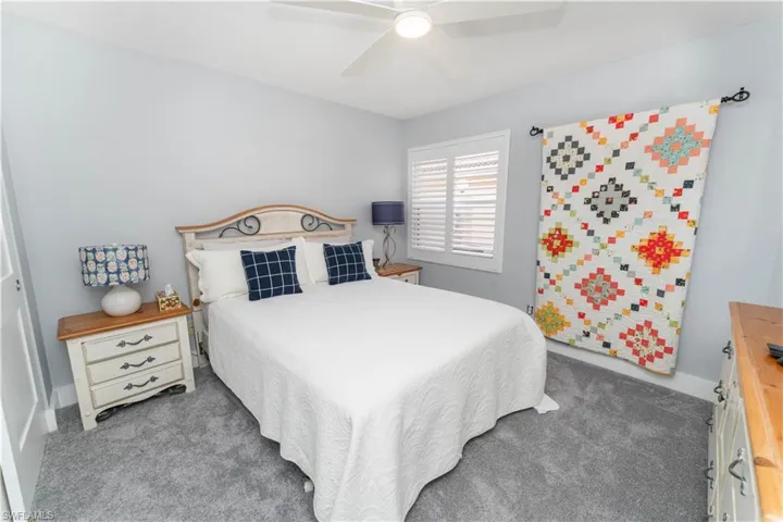 Bedroom with dark colored carpet and a ceiling fan