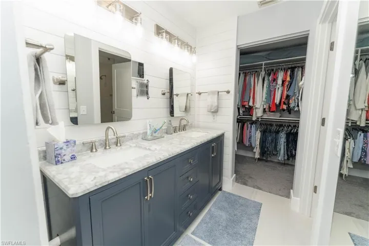 Full bathroom with a walk in closet and double vanity
