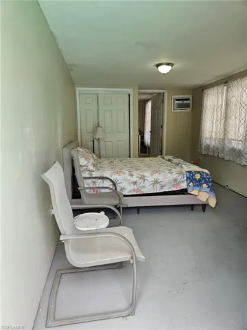Unfurnished bedroom featuring a wall mounted air conditioner