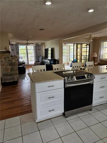 Kitchen featuring ceiling fan, stainless steel electric range oven, visible vents, and open floor plan
