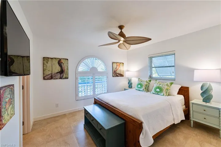 Bedroom with ceiling fan, baseboards, and multiple windows