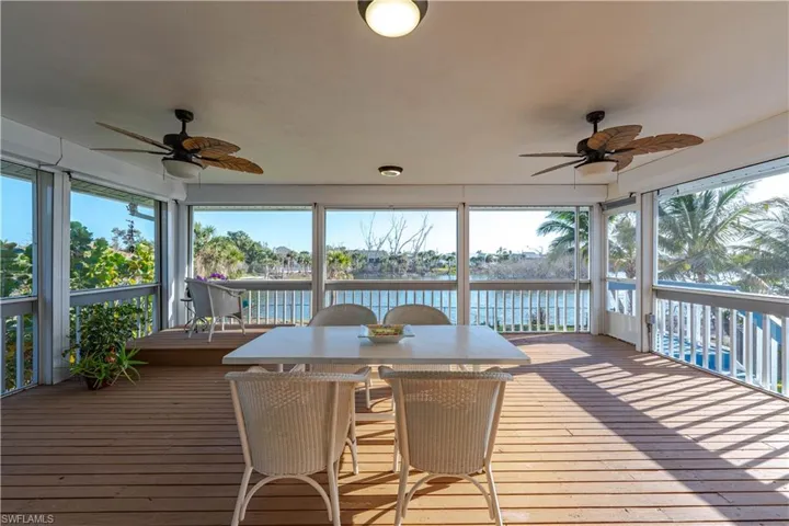 Sunroom with a water view, plenty of natural light, and a ceiling fan