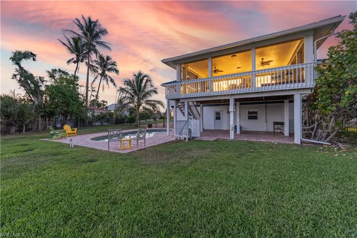 Back of property featuring a patio, stairway, a ceiling fan, fence, and a lawn