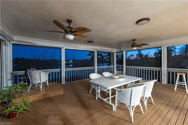 Sunroom with outdoor dining space and a ceiling fan