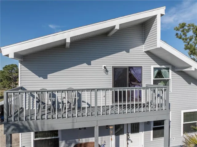 Front view of property with primary bedroom balcony