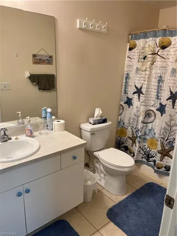 Bathroom with vanity, tile patterned floors, and toilet
