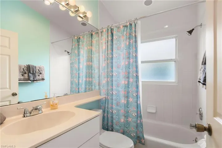 Bathroom featuring a single vanity with an integrated sink, polished chrome faucet, and a large mirror