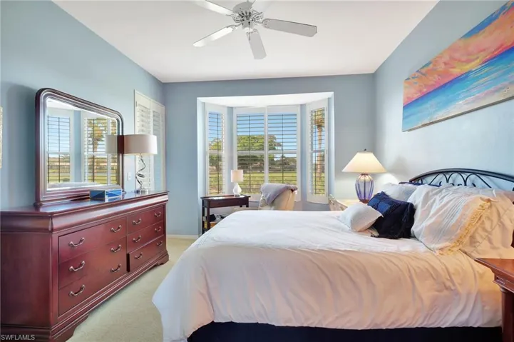 Bedroom with ceiling fan and light colored carpet