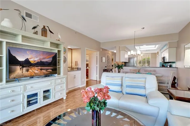 Living area featuring light wood-style floors and suspended lighting