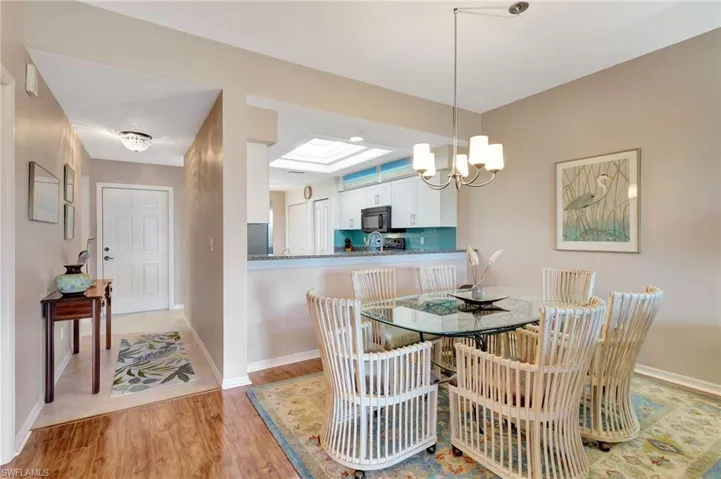Dining space featuring light wood-type flooring, a chandelier, and a skylight