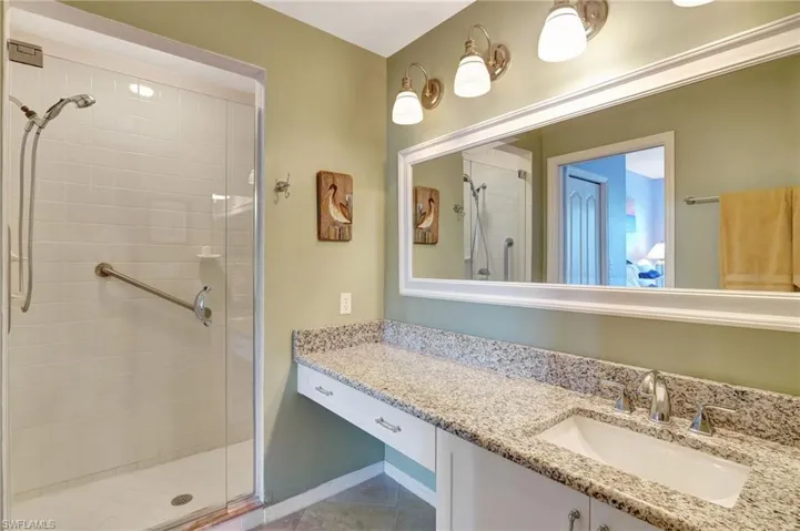 Bathroom with vanity, a shower stall, and tile patterned floors