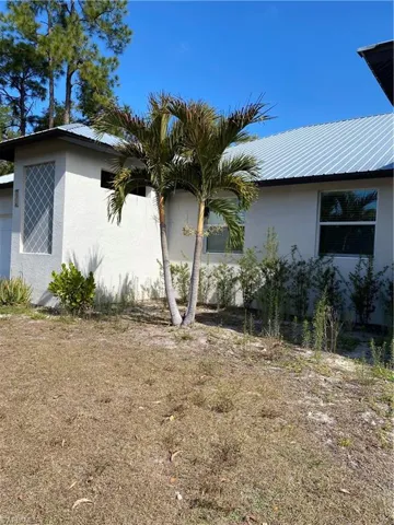 View of property exterior featuring stucco siding and a metal roof