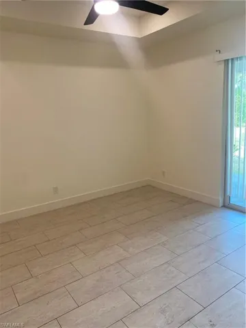 Spare room with a ceiling fan and wood tiled floors