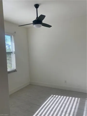 Unfurnished room featuring baseboards and ceiling fan