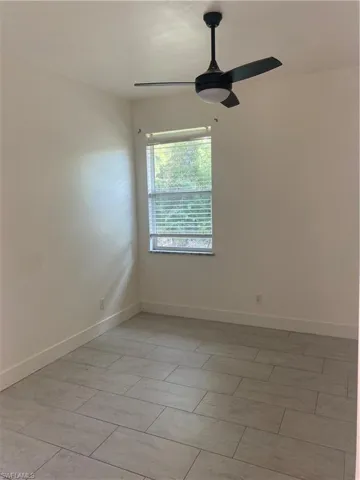 Unfurnished room featuring a ceiling fan and baseboards