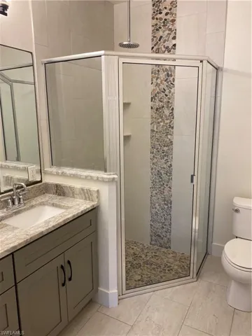 Full bathroom with vanity and a shower stall
