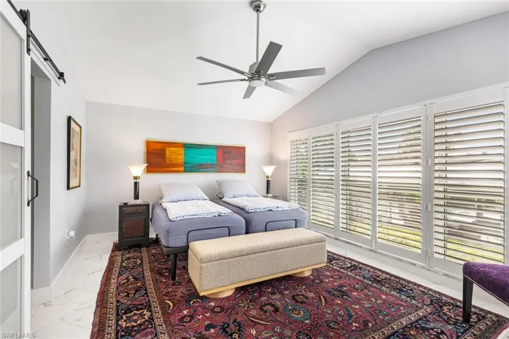 Large Owner's Suite with windows to the canal side of the home.  Suite has separate door to patio.  Sliding door leads to full bathroom with walk-in closet.