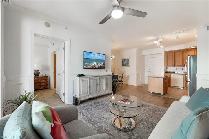 Living room featuring crown molding, track lighting, ceiling fan, and light hardwood / wood-style floors