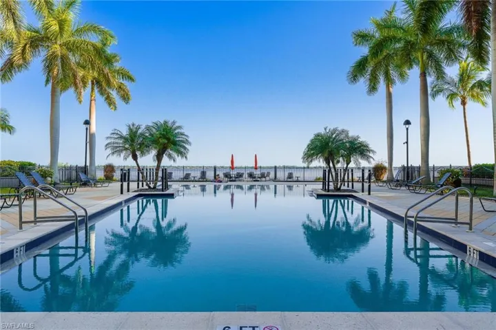 View of swimming pool with a water view and a patio area