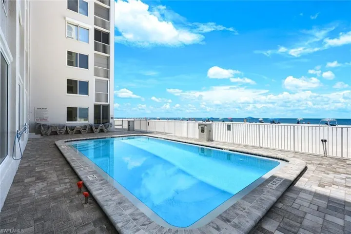 Community pool featuring a water view and a patio area