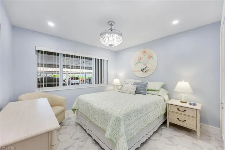 Bedroom featuring light marble finish flooring, a chandelier, and recessed lighting