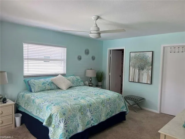 Window with horizontal blinds, overhead ceiling fan, and light-toned wall-to-wall carpeting